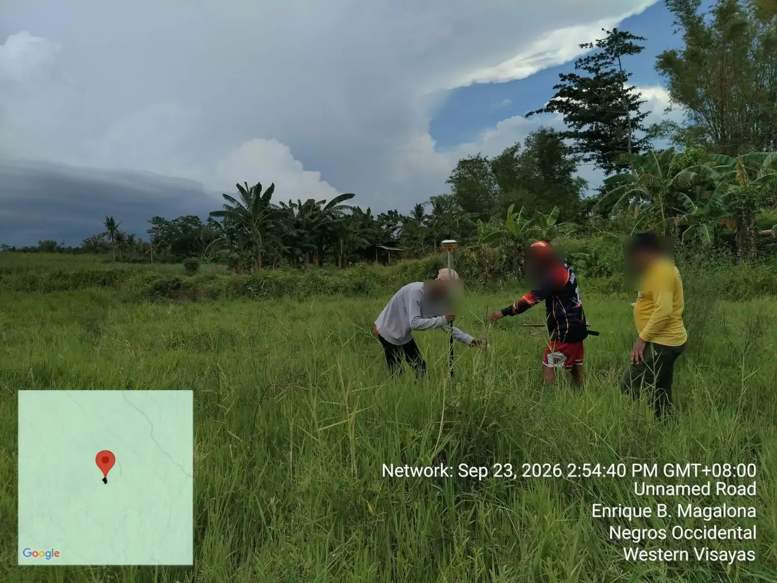 Field crew using a GNSS survey pole in grassland in E. B. Magalona, Negros Occidental