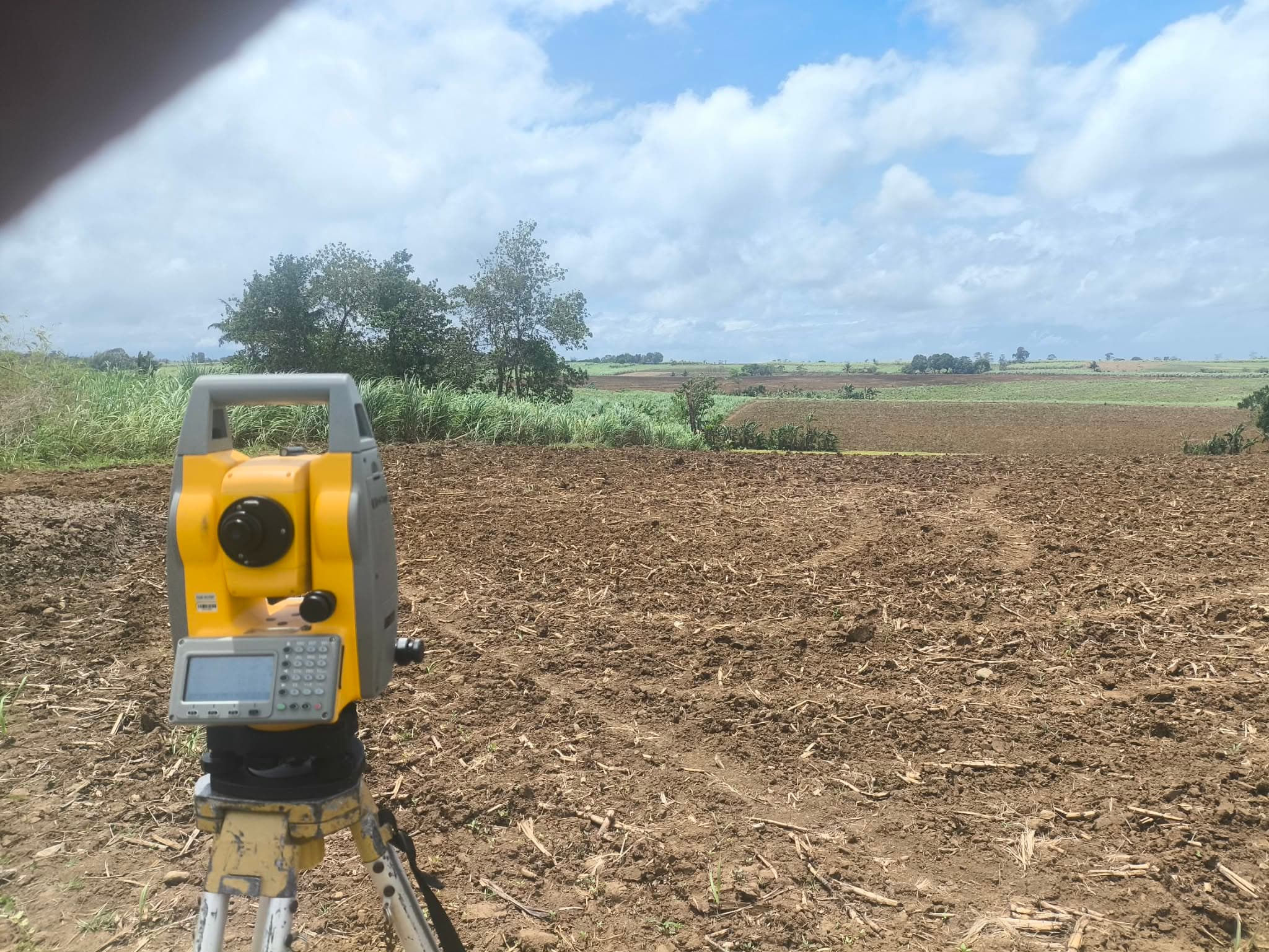 Total station set up on freshly plowed farmland for a topographic survey