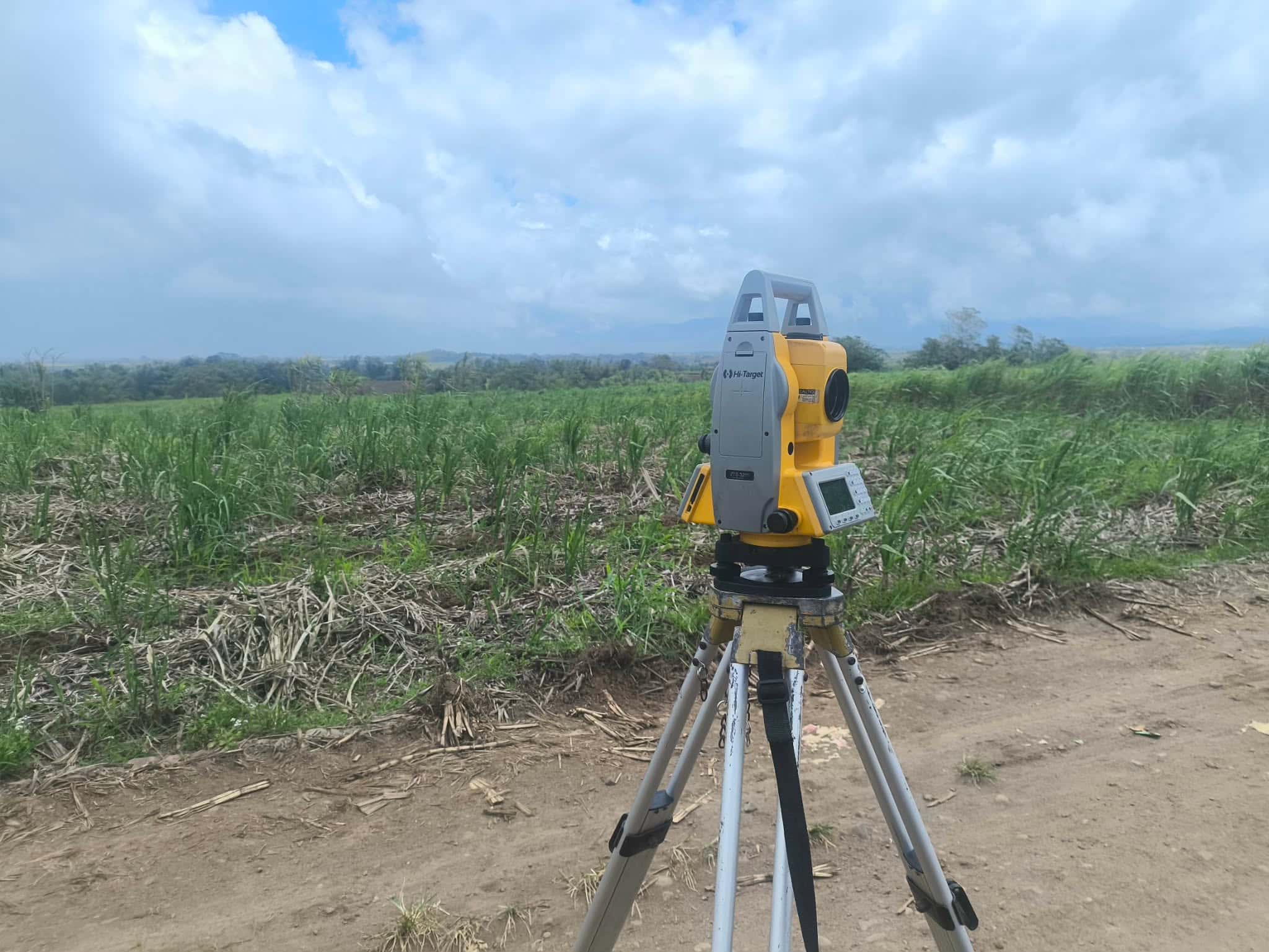 Survey equipment set up on open farmland during a lot consolidation survey